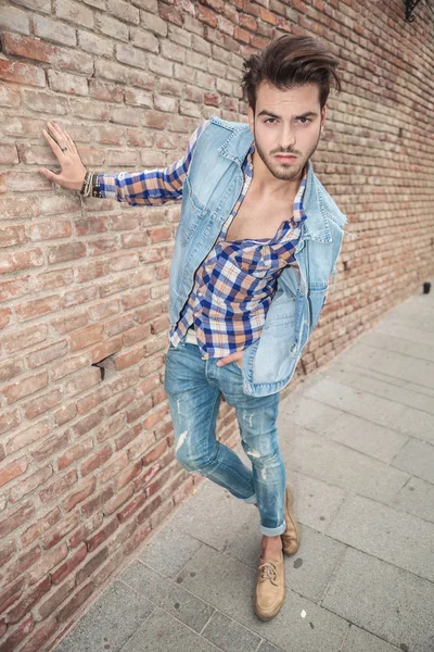 Uomo appoggiato con una mano al muro — Foto Stock