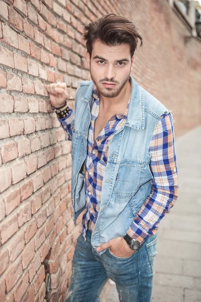 Hombre posando para la cámara cerca de una pared de ladrillo — Foto de Stock