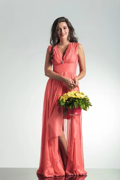 Mujer elegante feliz en vestido rojo sosteniendo una cesta de flores —  Fotos de Stock