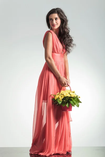 Side view of an elegant woman holding a flower basket — Stock Photo, Image