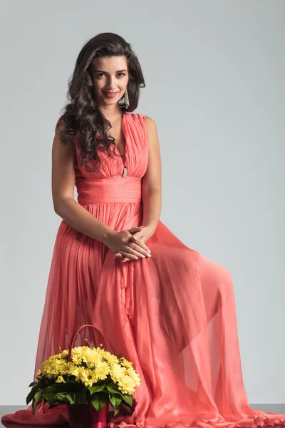 Mulher feliz em vestido vermelho perto de cesta de flores — Fotografia de Stock