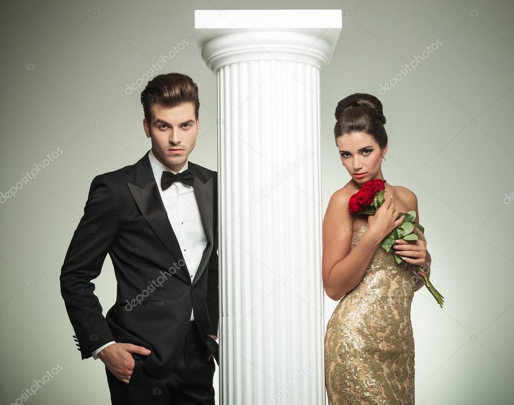 Elegant young couple posing near column