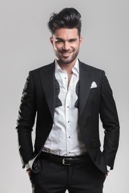 mutlu bir adam smokin elleri cebinde tutuyor