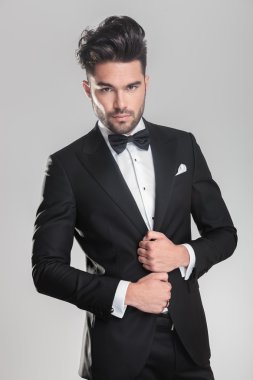 genç adam ajusting onun smokin kameraya ararken