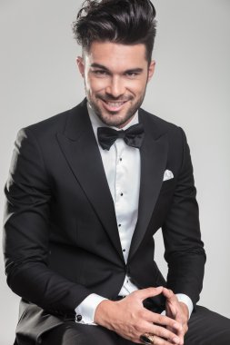  oturma ve ellerini bir arada tutan genç adam