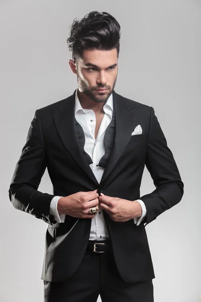 Young man wearing tuxedo closing his jacket — Stock Photo, Image