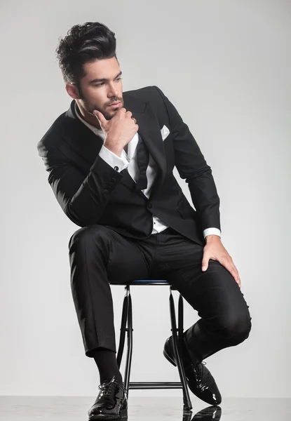 Man in tuxedo thinking, holding one hand to his chin. — Stock Photo, Image