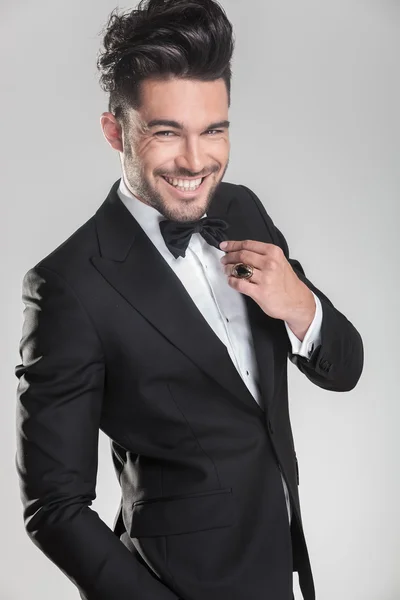 Young man in tuxedo ajusting his bow tie — Stock Photo, Image