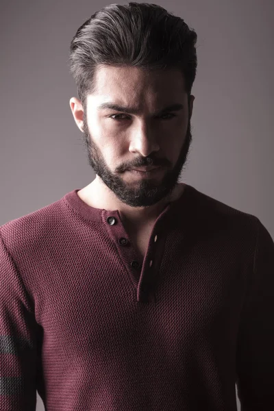 Бородач в бордовом свитере, смотрит в камеру — стоковое фото