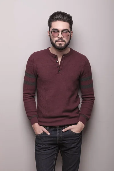 Ung man bär solglasögon och en vinröd tröja — Stockfoto