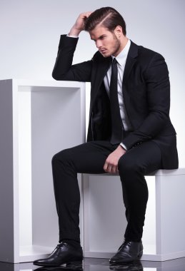 Başını tırmalamak süre bir masada oturan iş adamı