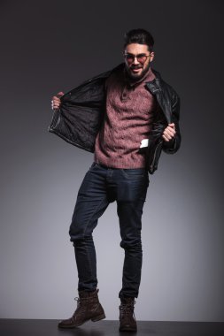 yakışıklı bir adam siyah deri ceketini çekerek 