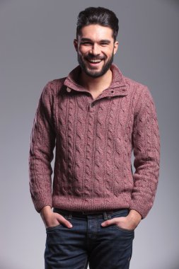 elleri cebinde tutarken gülen genç adam