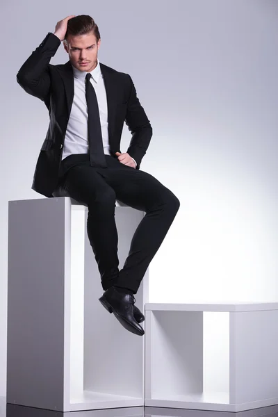 Homem de negócios sentado em uma mobília branca moderna — Fotografia de Stock