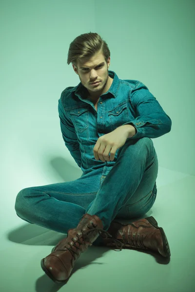 Attractive young fashion man sitting on the floor — Stock Photo, Image