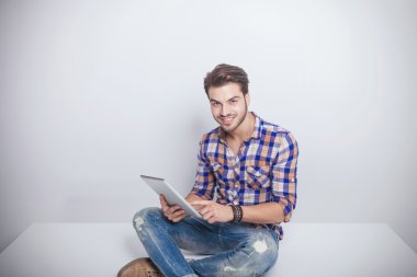 tablet pad bilgisayar tutan genç moda erkek.