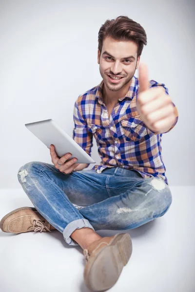 Fashion man sitting andz showing thumbs up gesture — Stock Photo, Image