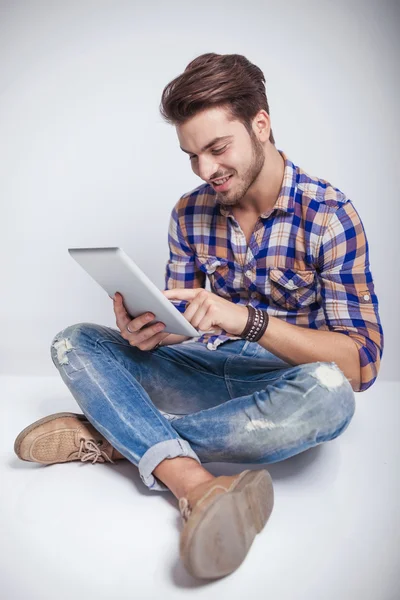 Ungt mode man sitter när du använder en tablet PC — Stockfoto