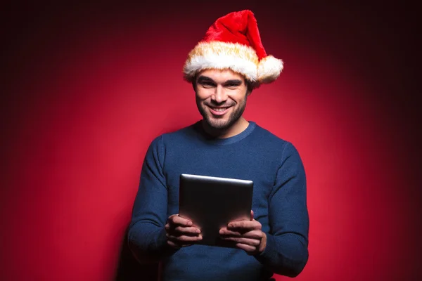 Young santa man holding a tablet pad computer — Stock Photo, Image