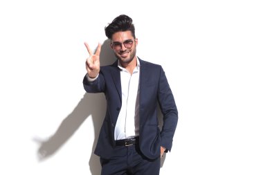 Zafer işaret gösteren gülümseyen iş adamı
