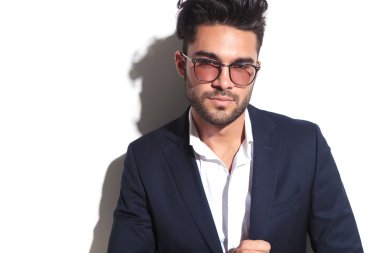 Kameraya bakarak güneş gözlüğü takmış genç iş adamı 