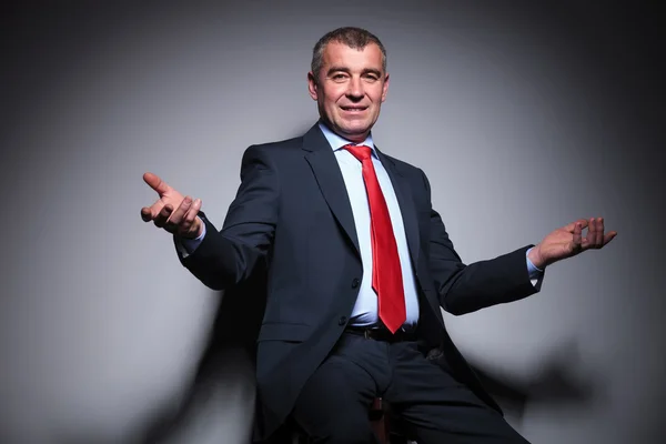 Middle aged business man sitting on a stool — Stock Photo, Image