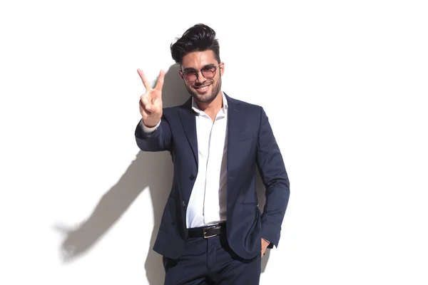 Smiling business man showing the victory sign — Stock Photo, Image