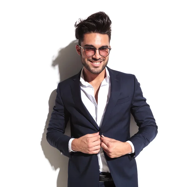 Smiling business man unbuttoning his jacket — Stock Photo, Image