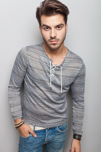  young fashion man holding one hand in pocket 