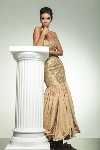 Elegante mode vrouw in een gouden jurk — Stockfoto