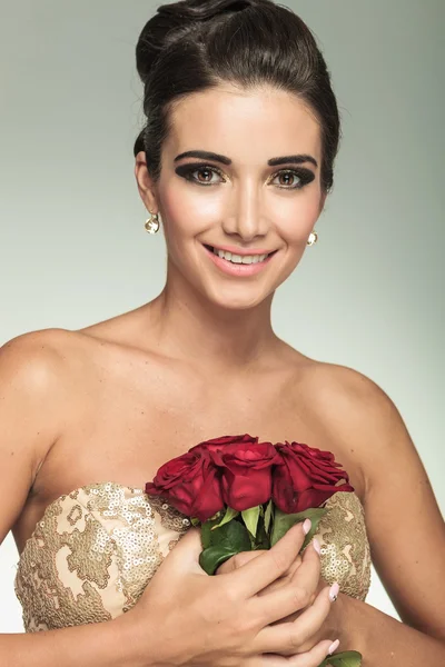 Mulher linda em vestido dourado com rosas — Fotografia de Stock