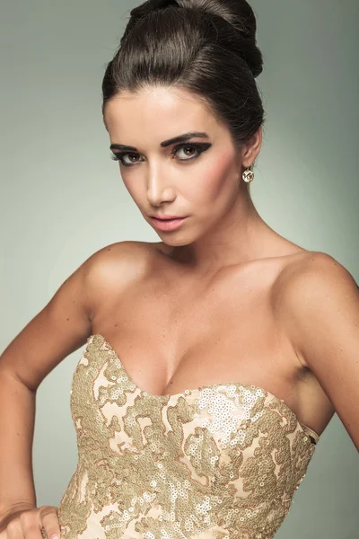 Mooie jonge vrouw in een gouden jurk — Stockfoto