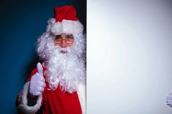 Santa Claus innehar en tomt ombord till vänster — Stockfoto