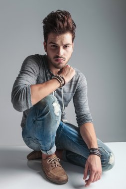 Yakışıklı moda adam gri studio arka plan üzerinde rahatlatıcı