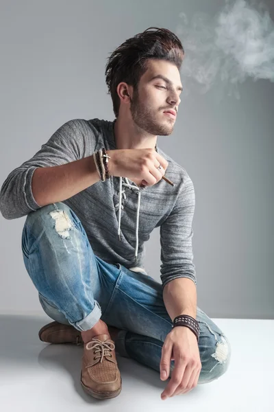 Молодой модник курит сигарету — стоковое фото