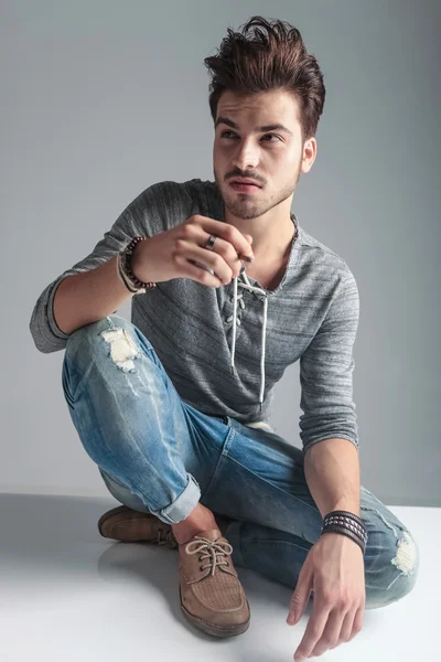 Fashion man sitting on the floor looking up — Stock Photo, Image