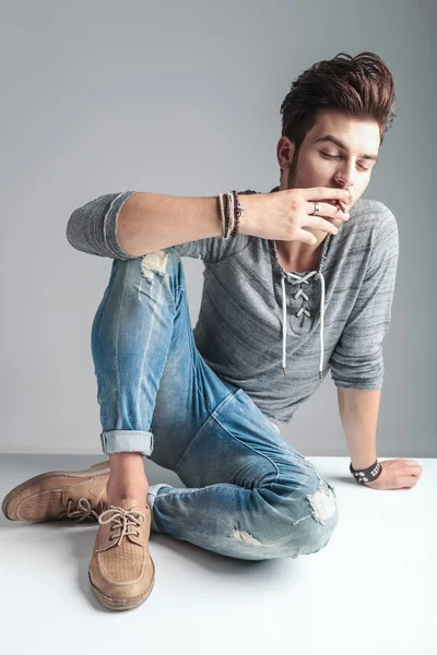Fashion man smoking a cigarette while relaxing — Stock Photo, Image