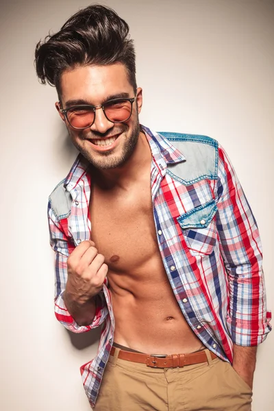 Sorrindo homem da moda puxando sua camisa — Fotografia de Stock