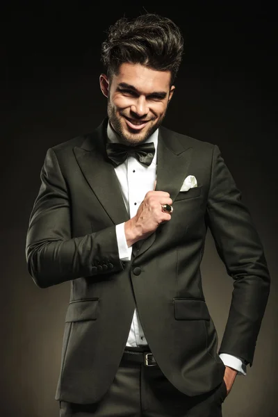 Business man smiling for the camera while fixing his tuxedo — Stock Photo, Image