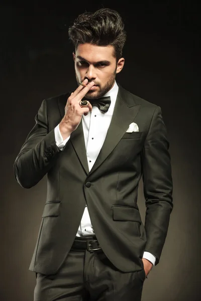 Hombre de negocios sosteniendo una mano en el bolsillo mientras fuma — Foto de Stock