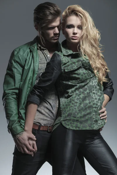 Couple posing on studio background while holding hands — Stock Photo, Image