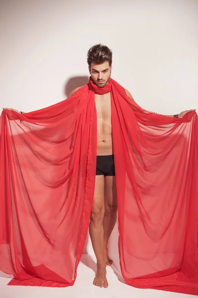 Un homme tenant un textile rouge autour du cou . — Photo