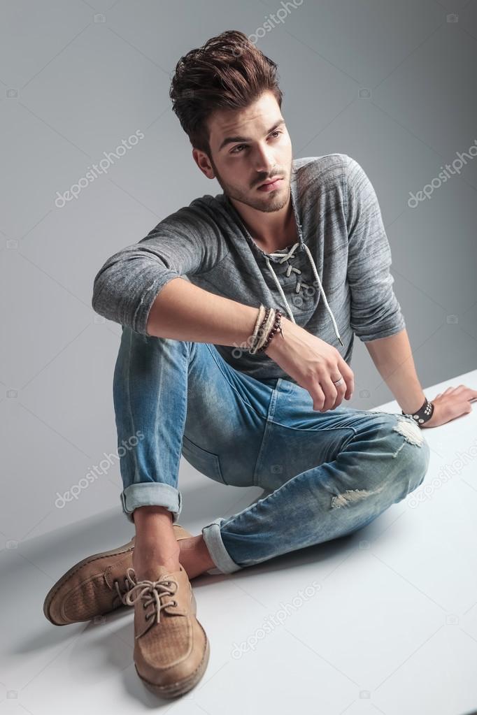 young casual fashion man sitting on the floor 