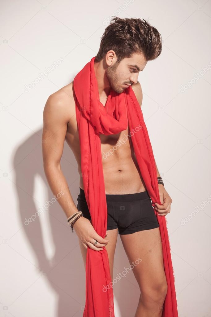 naked man holding a big red scarf around him. 