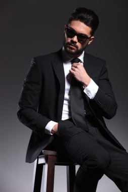 Bir taburede oturan yakışıklı genç zarif iş adamı