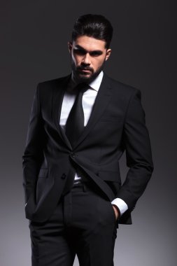 Elleri ceplerinde tutan çekici genç iş adamı