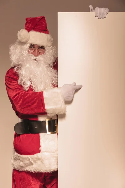 Santa claus verwijst naar een leeg bord — Stockfoto