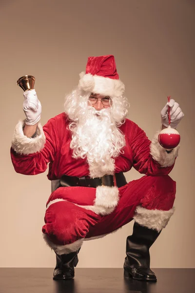 Babbo Natale seduto con una campana nella mano sinistra — Foto Stock