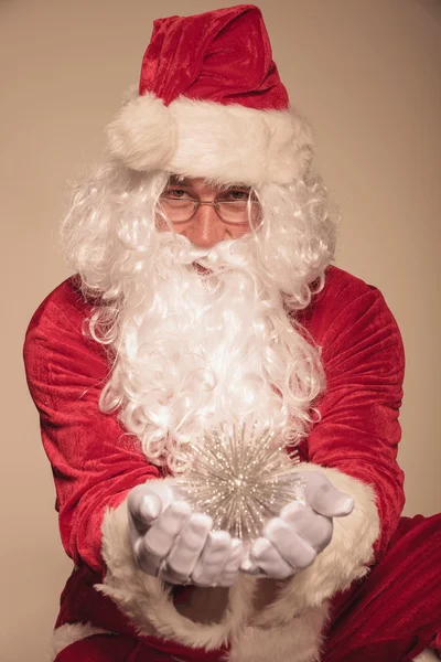 Santa Claus presenting a christmas ornament — Stock Photo, Image