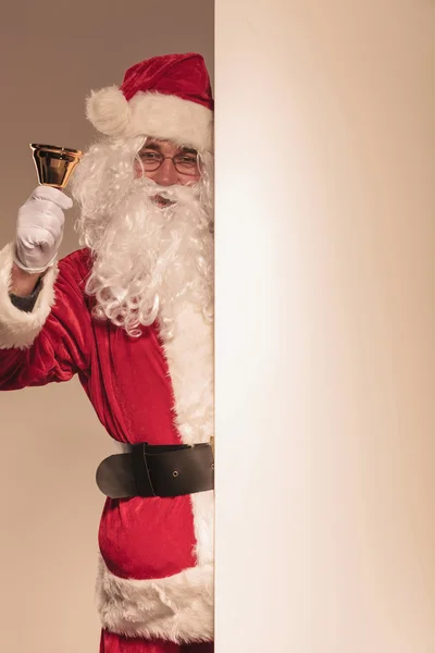 Santa Claus sosteniendo una campana dorada en su mano — Foto de Stock